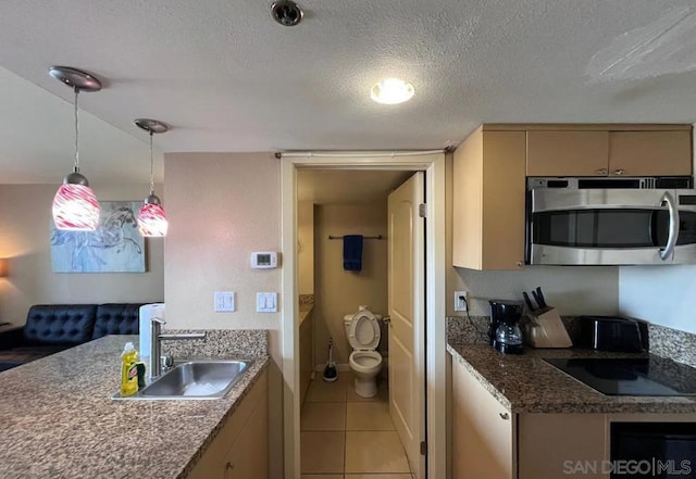 kitchen with black electric stovetop, tile patterned flooring, a textured ceiling, sink, and decorative light fixtures