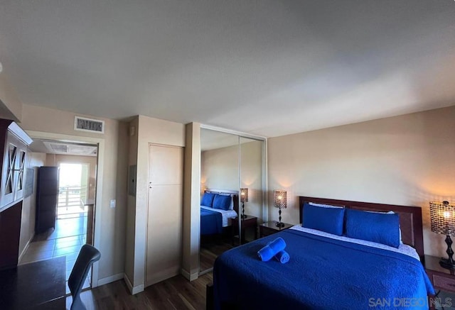 bedroom with dark hardwood / wood-style flooring and a closet