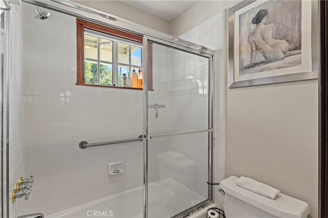 bathroom featuring enclosed tub / shower combo and toilet