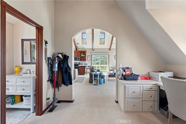 office space featuring vaulted ceiling and light colored carpet