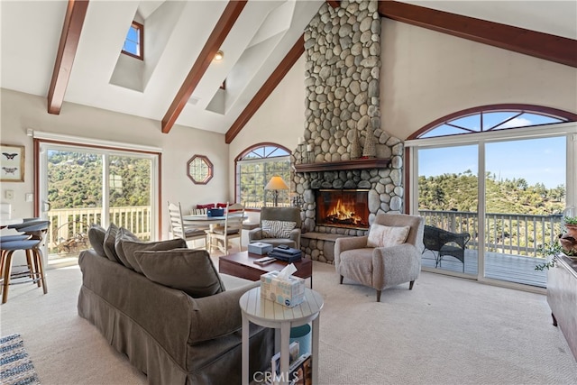 living room with light colored carpet, a fireplace, high vaulted ceiling, and a healthy amount of sunlight