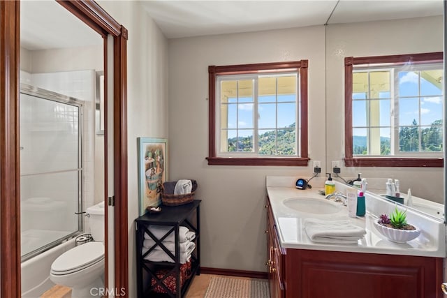 full bathroom with shower / bath combination with glass door, vanity, and toilet