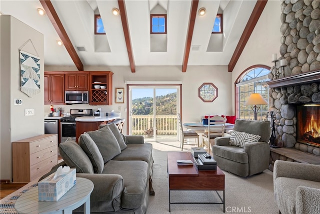 living room featuring vaulted ceiling with skylight, a fireplace, light hardwood / wood-style floors, and a wealth of natural light