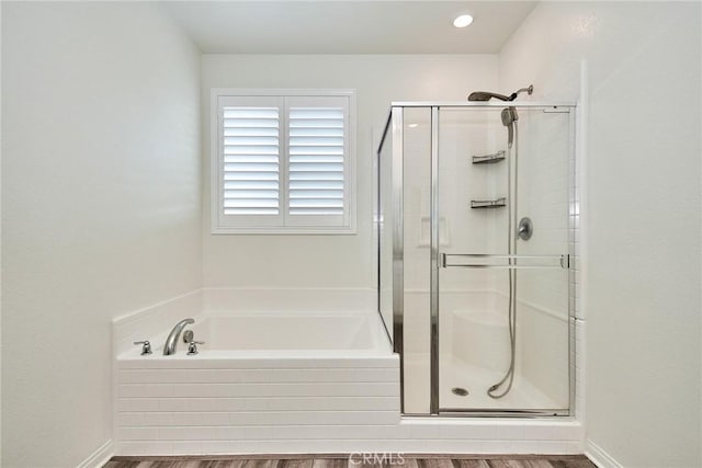 bathroom featuring wood-type flooring and separate shower and tub