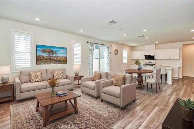 living room with plenty of natural light and light hardwood / wood-style flooring