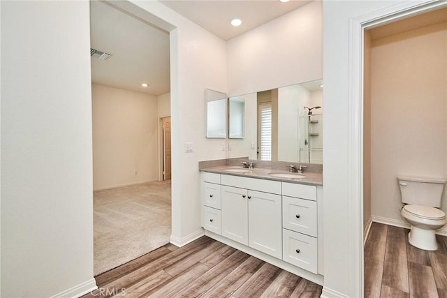 bathroom featuring vanity, hardwood / wood-style flooring, and toilet