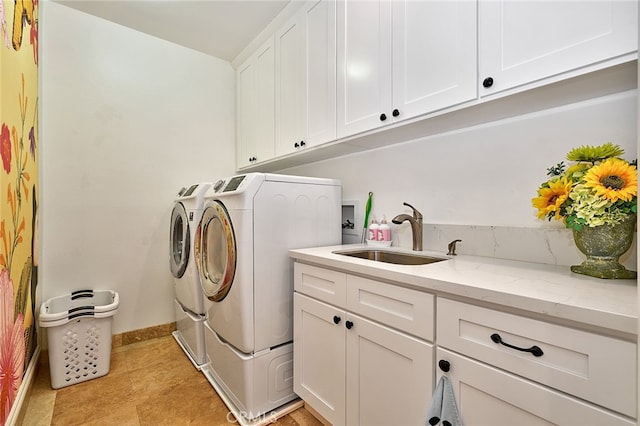 laundry area featuring washer and clothes dryer, cabinets, and sink