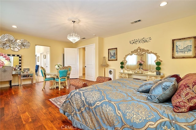 bedroom with a notable chandelier and dark hardwood / wood-style flooring