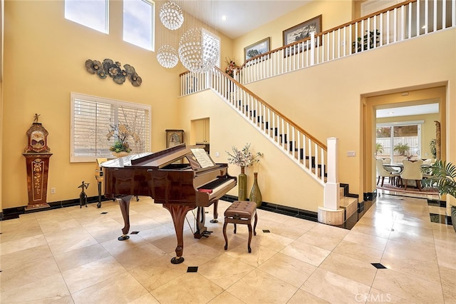 misc room with an inviting chandelier, a towering ceiling, and light tile patterned flooring