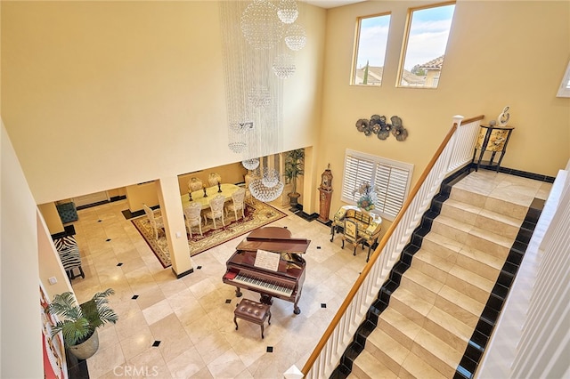 staircase with a towering ceiling and a chandelier