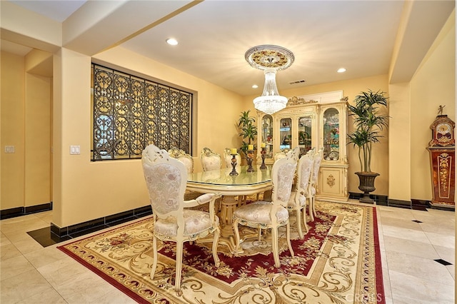 dining area with light tile patterned flooring and a chandelier