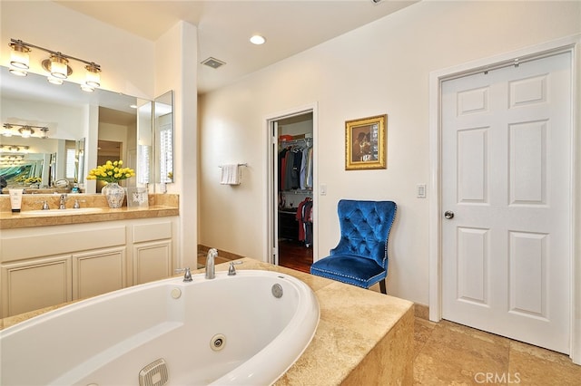 bathroom with tiled tub and vanity