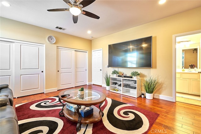 living room with wood-type flooring, sink, and ceiling fan