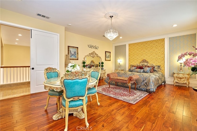 bedroom with hardwood / wood-style flooring and a chandelier