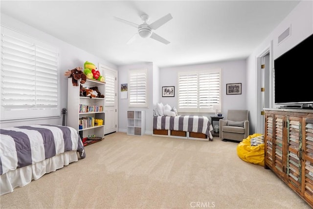 bedroom featuring light carpet, ceiling fan, and visible vents