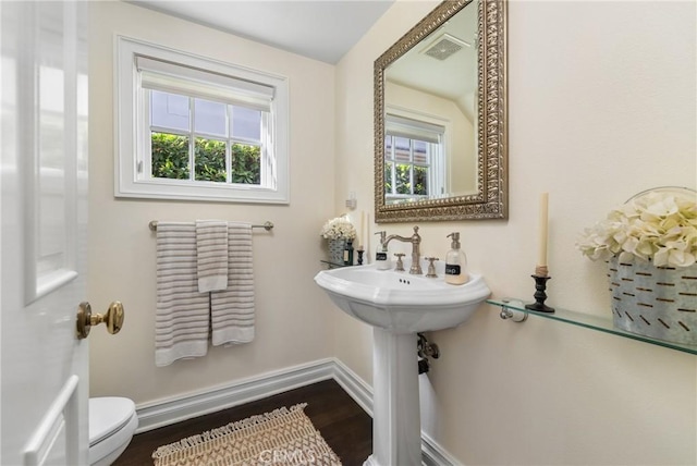 bathroom with hardwood / wood-style flooring and toilet