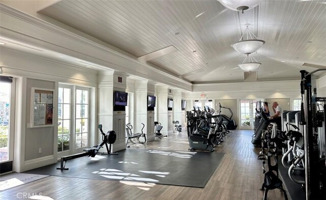 gym with wood ceiling, crown molding, vaulted ceiling, and wood finished floors