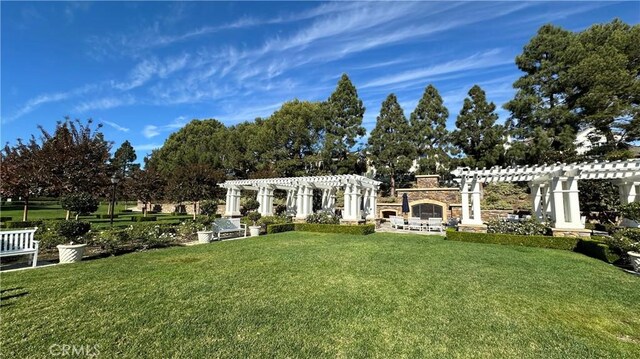 exterior space featuring an outdoor stone fireplace and a pergola