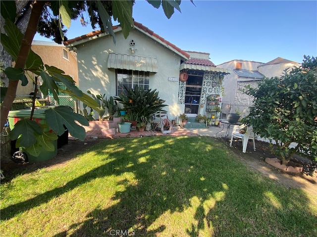 back of property featuring a patio area and a yard