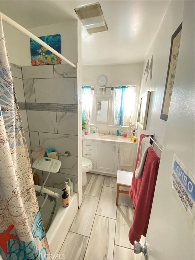 full bathroom featuring vanity, toilet, and shower / bathtub combination with curtain