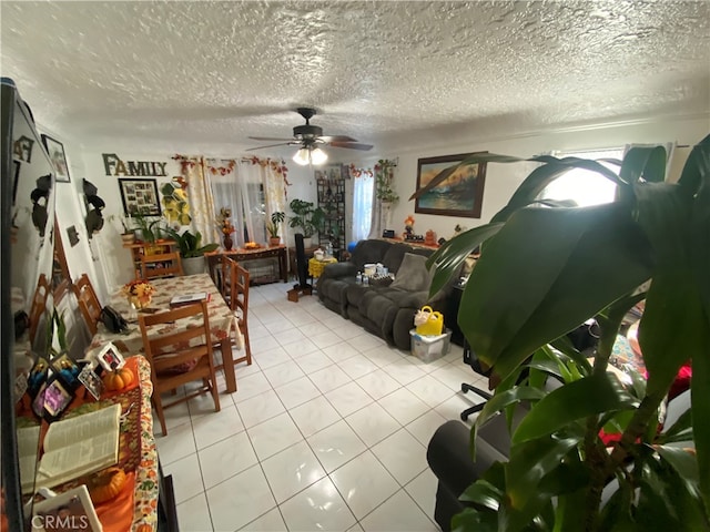 living room featuring a textured ceiling, light tile patterned flooring, and ceiling fan