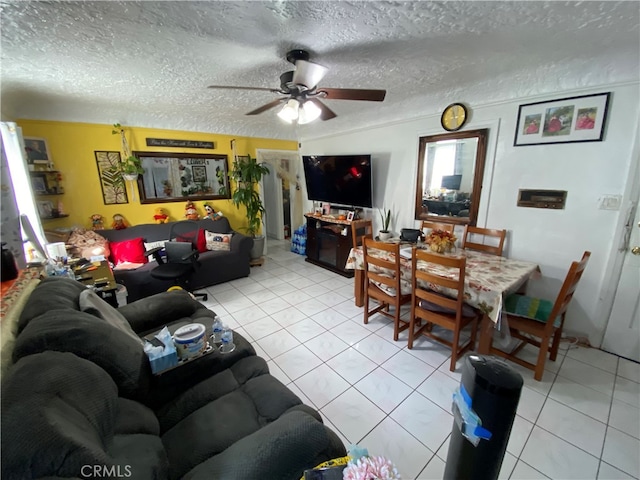 living room featuring a textured ceiling, light tile patterned floors, and ceiling fan