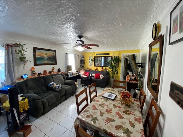 tiled dining area with a textured ceiling and ceiling fan