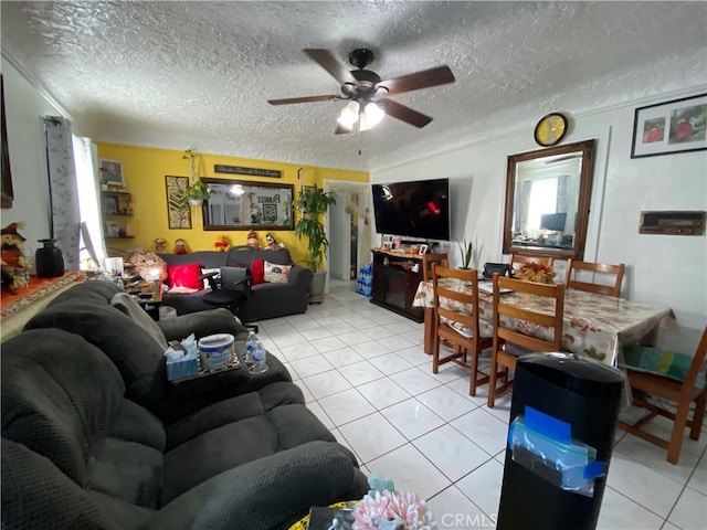 living room featuring ceiling fan, a textured ceiling, and light tile patterned floors