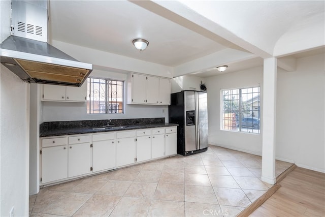 kitchen featuring stainless steel fridge, island exhaust hood, white cabinetry, and sink