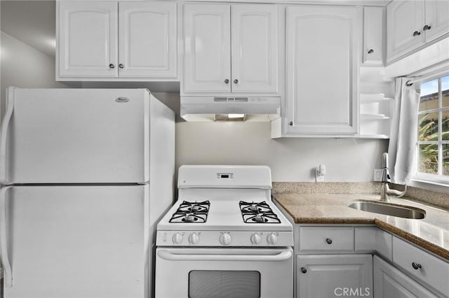 kitchen with stone countertops, white cabinetry, white appliances, and sink