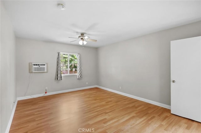 empty room featuring a wall mounted AC, ceiling fan, and light hardwood / wood-style flooring