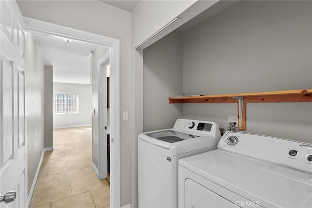 laundry room featuring washer and clothes dryer and light tile patterned floors