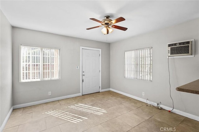 unfurnished room featuring a wall mounted AC, ceiling fan, a healthy amount of sunlight, and light tile patterned flooring