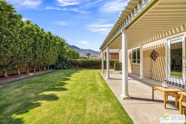 view of yard featuring a mountain view, a pergola, and a patio