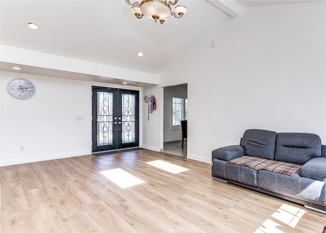 unfurnished living room with french doors, beamed ceiling, light hardwood / wood-style floors, and a notable chandelier