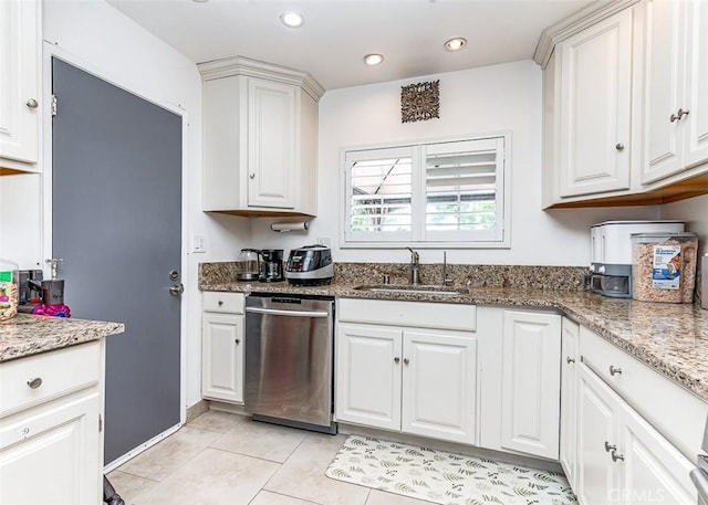 kitchen with stainless steel dishwasher, white cabinets, light stone countertops, and sink