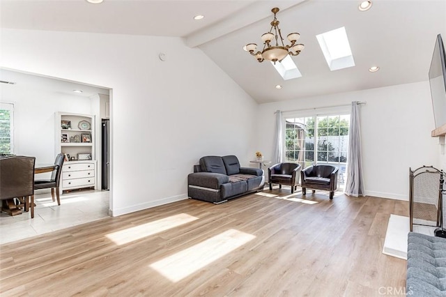 sitting room featuring high vaulted ceiling, a skylight, light wood-type flooring, beam ceiling, and a chandelier