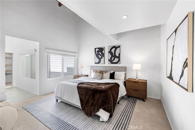 bedroom with high vaulted ceiling and light carpet