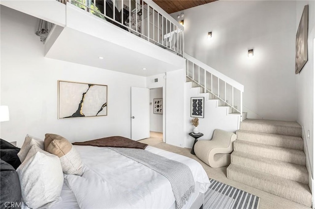 carpeted bedroom featuring a towering ceiling