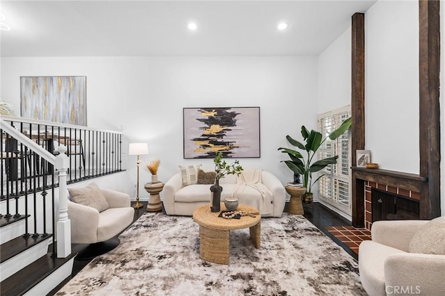 living room featuring a tile fireplace and dark hardwood / wood-style floors