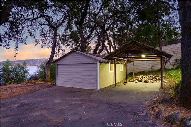 garage at dusk featuring a carport