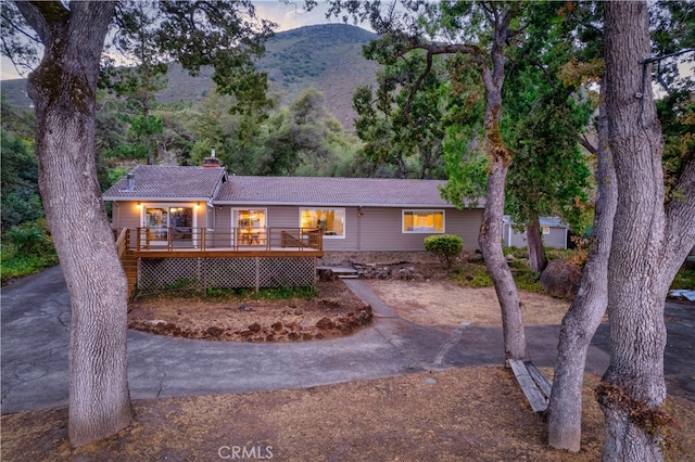 ranch-style home featuring a deck with mountain view