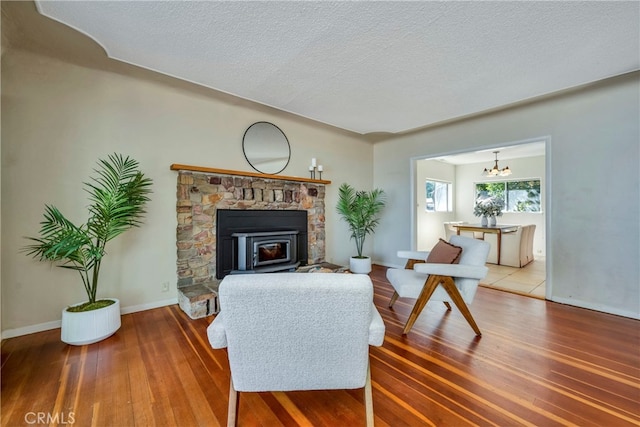 living room featuring hardwood / wood-style flooring, a chandelier, and a textured ceiling