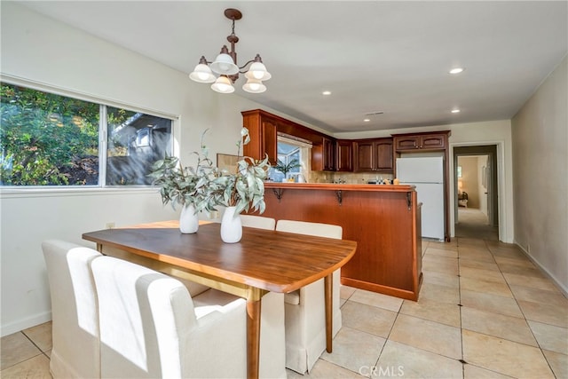 dining area featuring light tile patterned flooring and an inviting chandelier