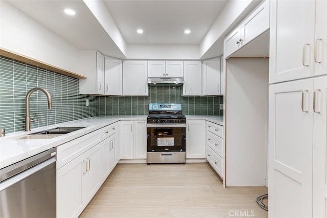 kitchen featuring white cabinetry, sink, backsplash, and appliances with stainless steel finishes