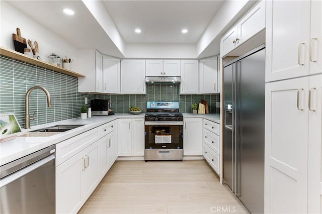 kitchen featuring stainless steel appliances, sink, white cabinets, and decorative backsplash