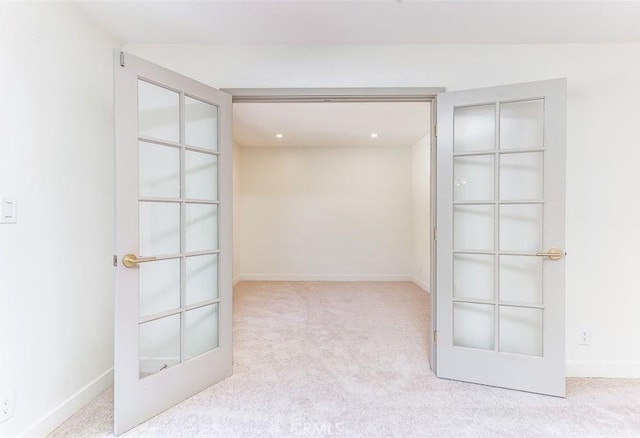 carpeted spare room featuring french doors