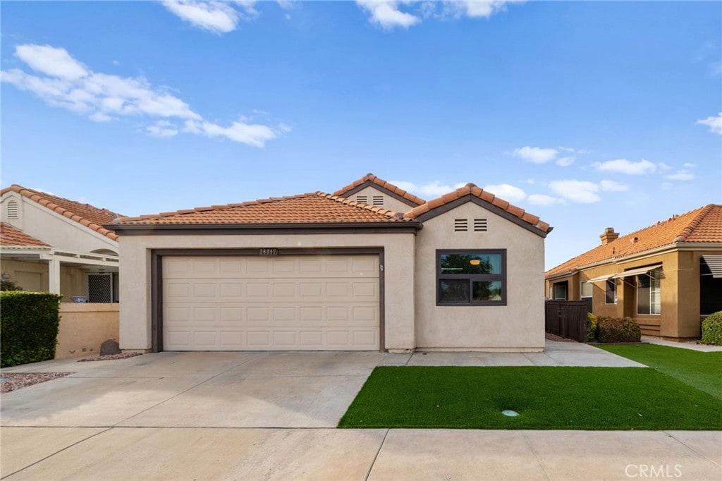 mediterranean / spanish home featuring a front yard and a garage