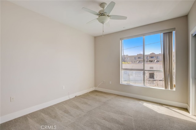 carpeted spare room featuring ceiling fan