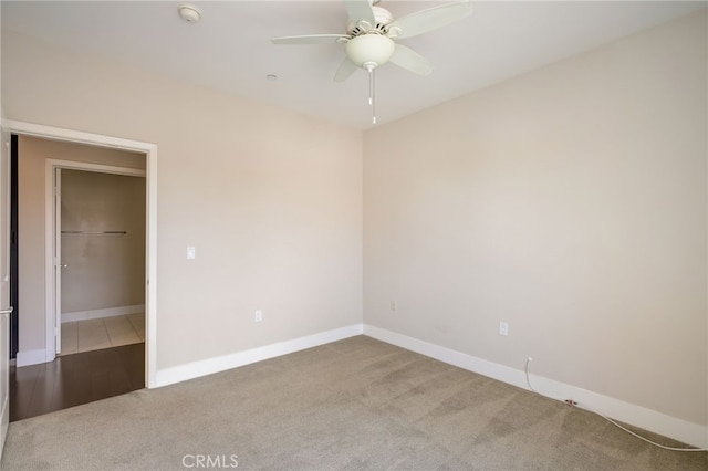 unfurnished bedroom featuring a walk in closet, carpet floors, a closet, and ceiling fan